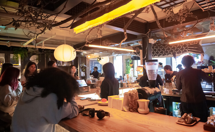 People sit around a café counter drinking coffee at Rooms at 915 Dupont.