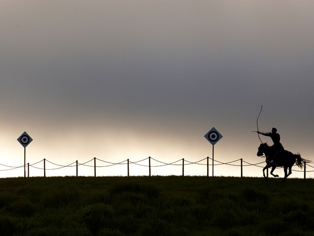 Archer on horseback aiming at target