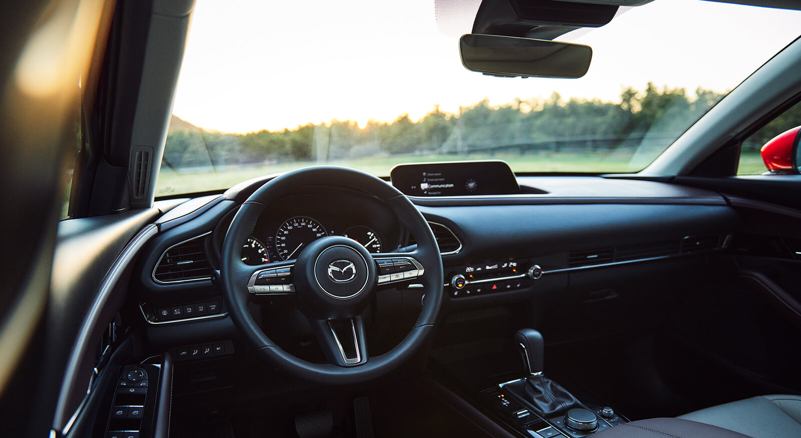 Driver’s side view of steering wheel and dashboard showing Mazda Connect display screen.