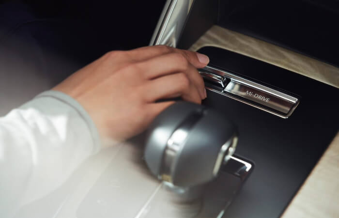 Driver’s toggling the Mi-drive switch in the CX-90's centre console.  
