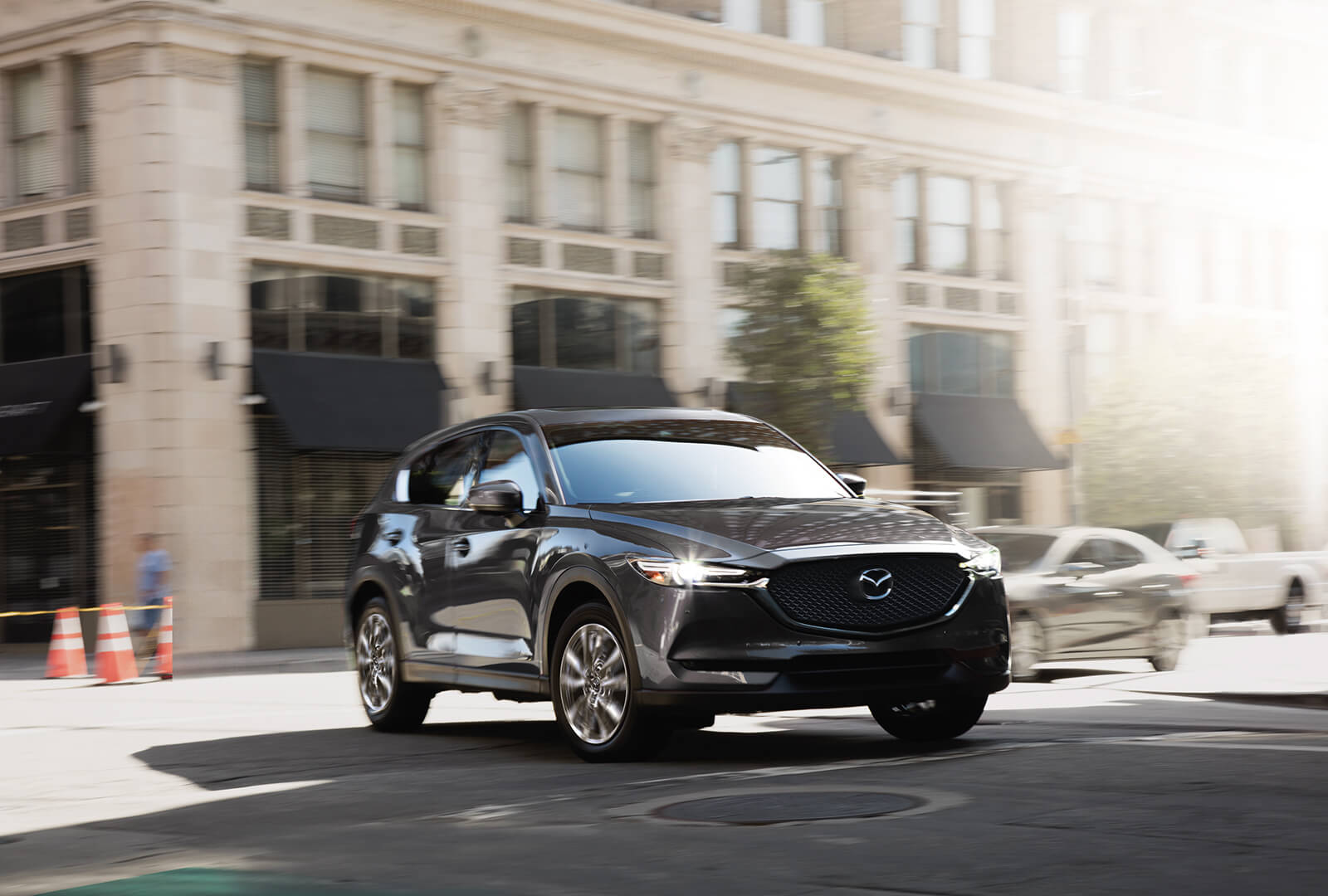 Grey Mazda CX-5 completing left turn on city street