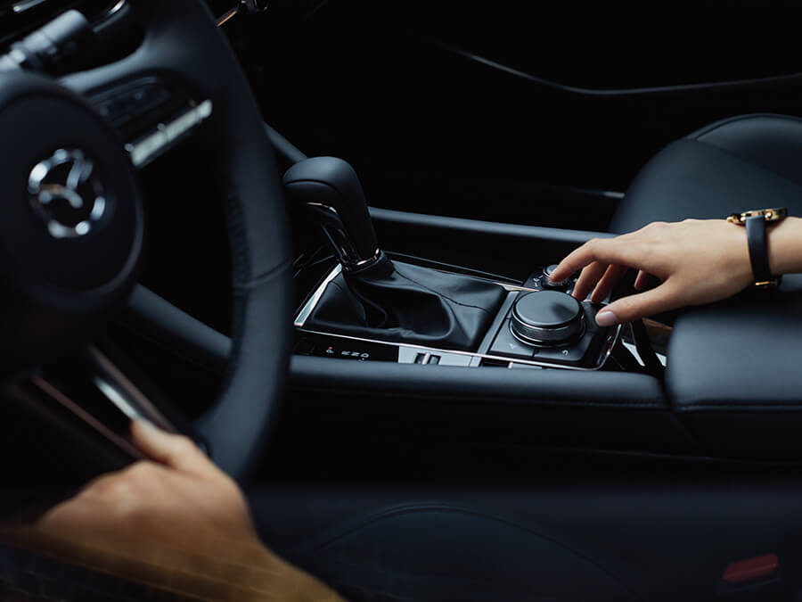 A close-up shot of a Mazda dashboard and steering wheel