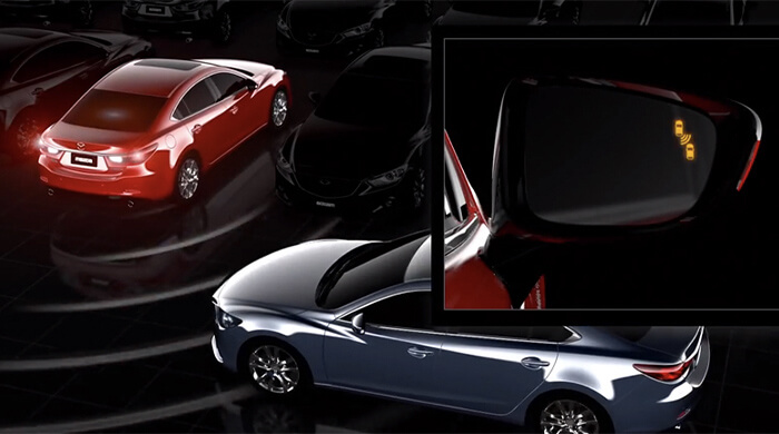 Red Mazda gets traffic alert from grey Mazda sedan at its rear