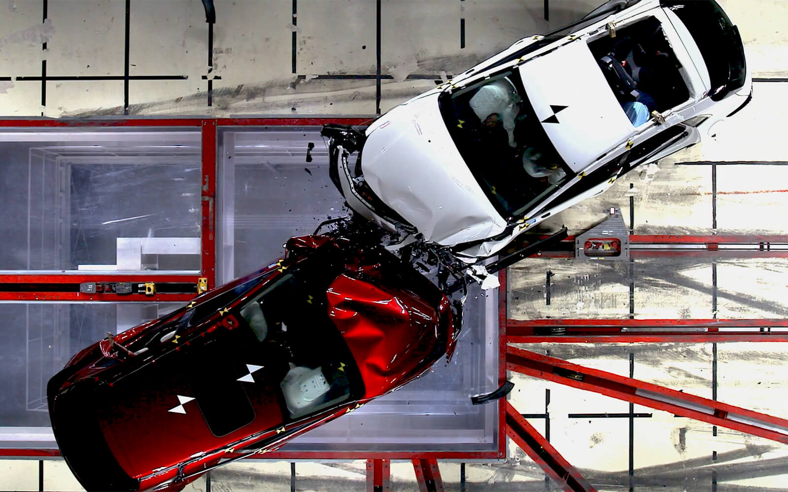 Overhead view of red Mazda and white Mazda colliding in testing facility