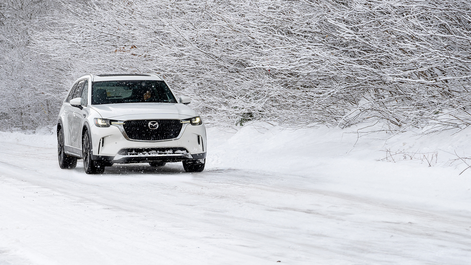 Soul Red Crystal Mazda CX-3 turns onto lightly snow-covered urban road 