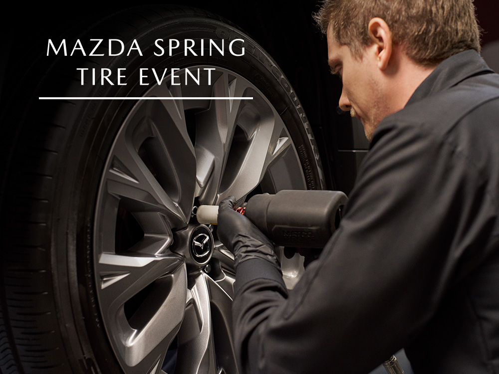 Mazda technician tightening lug nuts on wheel of vehicle