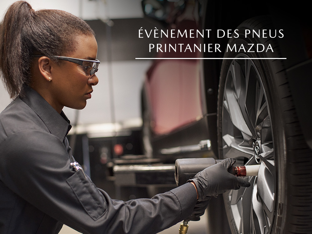 Une technicienne Mazda serrant les écrous de roue sur la roue du véhicule