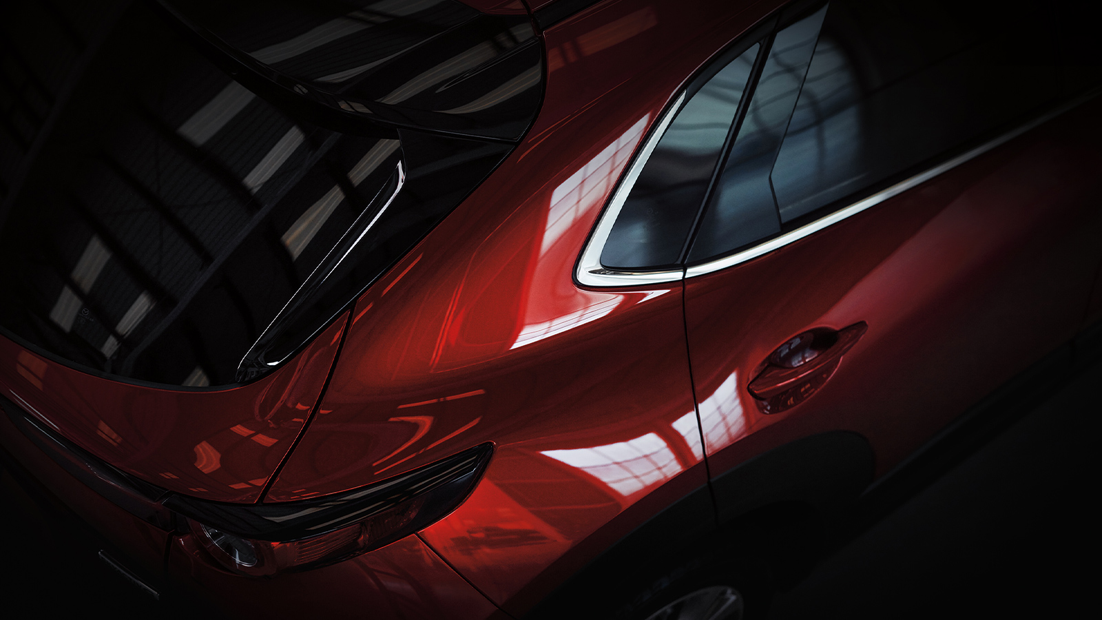 Close up of back ¾ Soul Red Crystal Metallic CX-30 from above, parked in studio environment. 