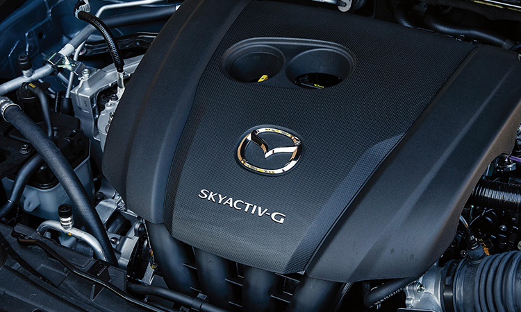 Inside the hood of the CX-30, an engine cover with a Mazda logo badge and Skyactiv G insignia.