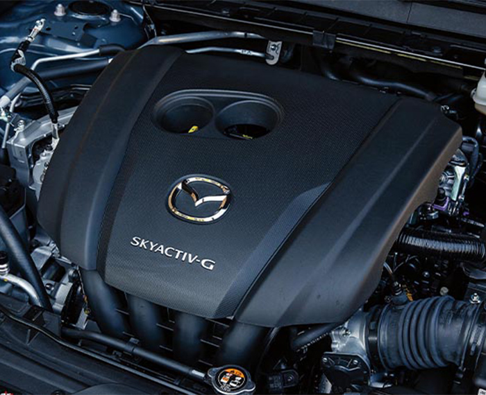 Inside the hood of the CX-30, an engine cover with a Mazda logo badge and Skyactiv G insignia. 