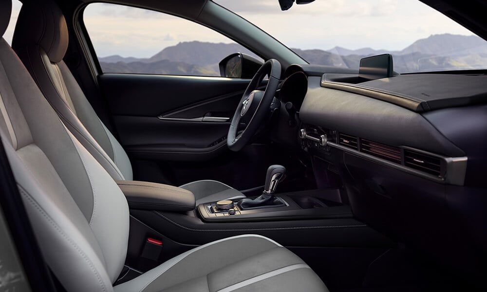 Interior front seats of a Mazda CX-30 from the passenger side door.