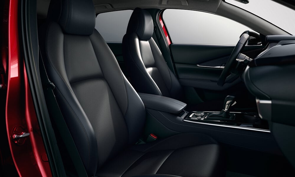 Interior front seats of a Mazda CX-30 from the passenger side door.