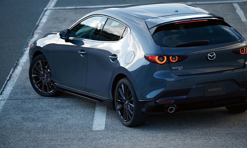 Rear driver’s side corner of a Deep Crystal Blue Mica Mazda3 Sport.